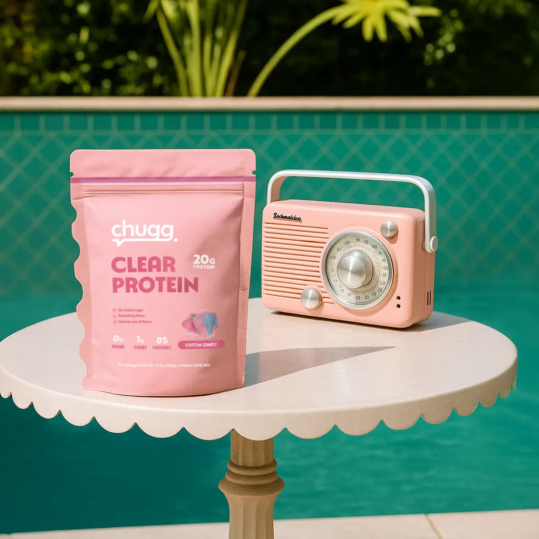 Cotton Candy Chugg clear protein package and vintage-style pink radio on a table with a pool in the background
