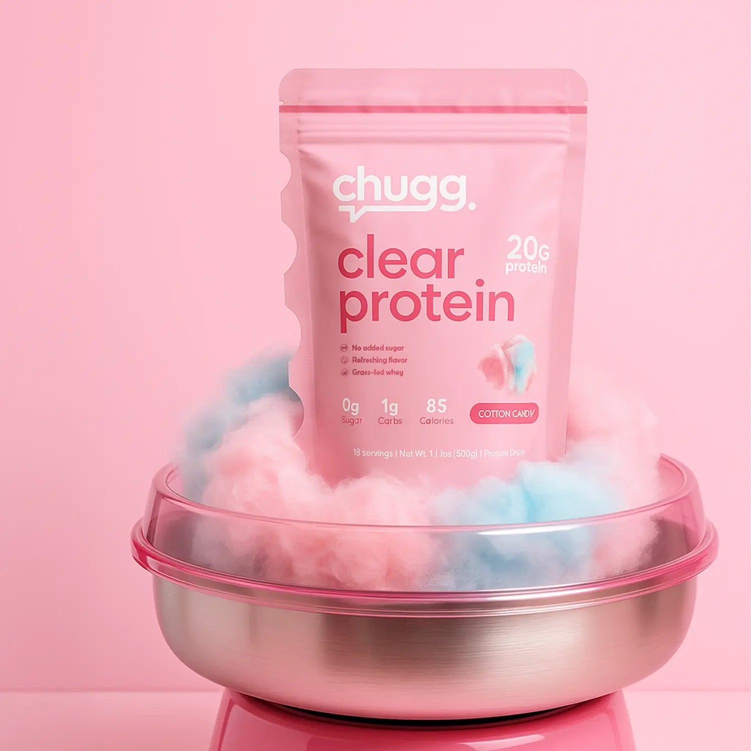 Pink pouch of Chugg Cotton Candy Clear Protein displayed on a cotton candy machine with cotton candy